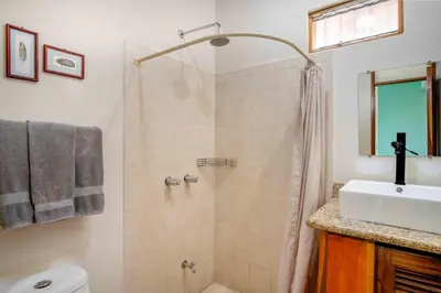 a bathroom with a shower and a sink at Tropical Condo with Spectacular Ocean Views, Panoramic Dining Terrace & Quick Walk to Beach in Coco