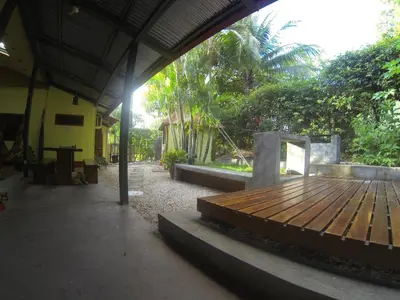 a porch with a wooden deck in a building at Indra Inn in Playa Grande