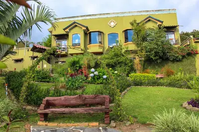 a yellow house with a bench in front of it at Casas del Toro in Monteverde Costa Rica