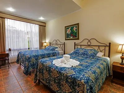 a hotel room with two beds with blue sheets at Casas del Toro in Monteverde Costa Rica