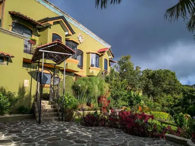 a yellow building with a garden in front of it at Casas del Toro in Monteverde Costa Rica