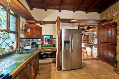 a kitchen with a stainless steel refrigerator and wooden cabinets at Villa Havana in Mal País