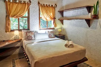 a bedroom with a large bed with two windows at Villa Havana in Mal País
