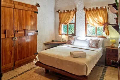 a bedroom with a large bed in a room with windows at Villa Havana in Mal País