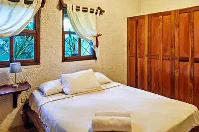 a bedroom with a large bed and two windows at Villa Havana in Mal País
