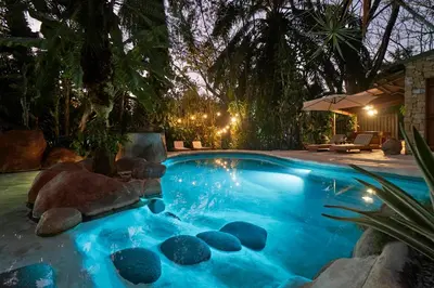 a swimming pool with a rock in the middle at Villa Havana in Mal País