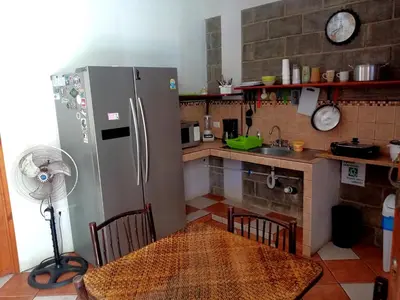 a kitchen with a stainless steel refrigerator and a table at Domi Cabin in Dominical
