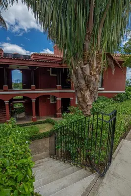 a gate in front of a house with a palm tree at Bright and cozy 3BR Condo - Bougainvillea - Reserva Conchal Golf Resort in Playa Conchal