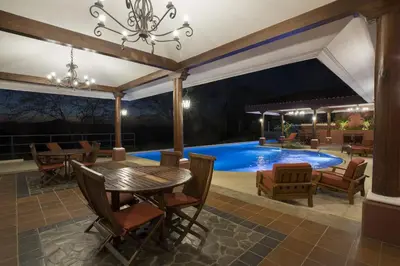 a patio with a table and chairs and a swimming pool at Bright and cozy 3BR Condo - Bougainvillea - Reserva Conchal Golf Resort in Playa Conchal