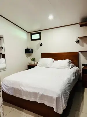 a bedroom with a large bed with white sheets at Apartamento Don Jarvey II in Monteverde Costa Rica