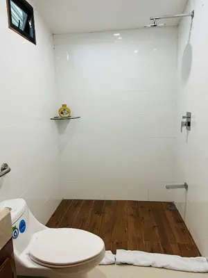 a bathroom with a toilet and a wooden floor at Apartamento Don Jarvey II in Monteverde Costa Rica