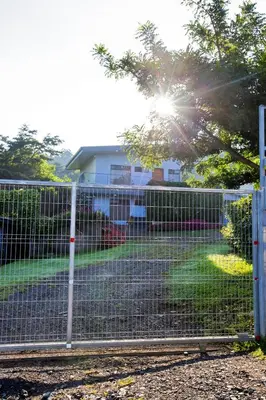 a fence with the sun shining behind it at Casa Suculenta ,Monteverde con Jacuzzi Privado y Lavandería in Monteverde Costa Rica