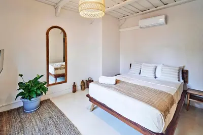 a bedroom with a bed and a mirror at Oceana Beachfront Lux 6BR Retreat Villa Private Yoga Shala in Mal País