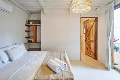 a bedroom with a bed with towels on it at Oceana Beachfront Lux 6BR Retreat Villa Private Yoga Shala in Mal País