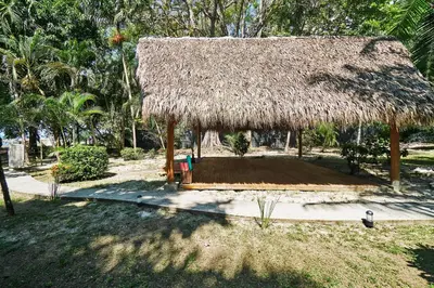 a hut with a thatched roof and a patio at Oceana Beachfront Lux 6BR Retreat Villa Private Yoga Shala in Mal País