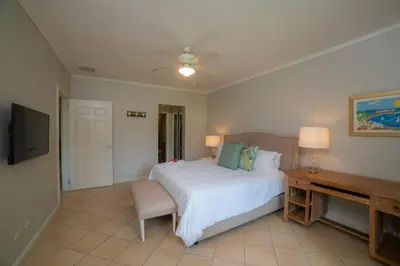 a bedroom with a bed and a desk and a television at Del Mar 4N 3 bdr Garden View in Los Suenos in Herradura