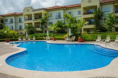 a swimming pool in front of a building at Del Mar 4N 3 bdr Garden View in Los Suenos in Herradura