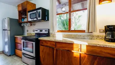 a kitchen with a stove and a microwave at Casa tropical - Fabulous tropical house in Tamarindo