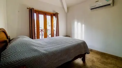 a bedroom with a bed in a room with a window at Casa tropical - Fabulous tropical house in Tamarindo
