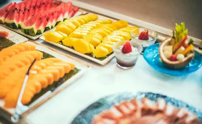a table topped with plates of fruit and desserts at Nayara Tented Camp in Fortuna