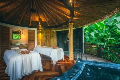 a room with two beds and a bathtub at Nayara Tented Camp in Fortuna