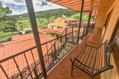 a balcony with a bench and a view at Hotel La Paz in Poasito