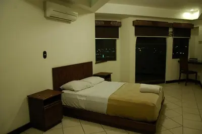 a bedroom with a bed and a window at Alajuela Backpackers Airport Hostel in Alajuela City