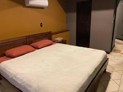 a bed with two red pillows in a bedroom at Alajuela Backpackers Airport Hostel in Alajuela City