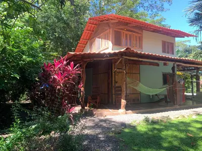 a small house with a hammock in front of it at Casita de los Sueños in Cabuya