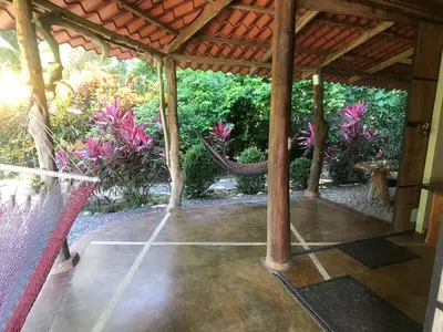 an outdoor patio with a hammock in a house at Casita de los Sueños in Cabuya