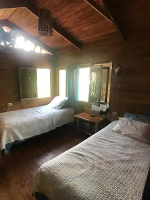 a bedroom with two beds and two windows at Casita de los Sueños in Cabuya