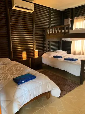 a bedroom with two beds and two lamps in it at Cabaña El Monasterio in Fortuna