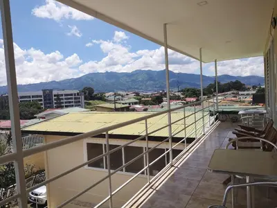 a balcony with chairs and a view of a city at HOTEL TERRAZAS BOUTIQUE in Los Yoses