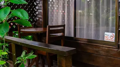a wooden bench and a table and a no smoking sign at La Fortuna Waterfall Bungalows in Fortuna