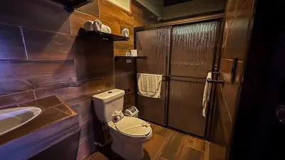 a small bathroom with a toilet and a sink at La Fortuna Waterfall Bungalows in Fortuna