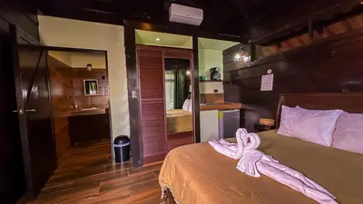 a bedroom with a bed with a pink bow on it at La Fortuna Waterfall Bungalows in Fortuna