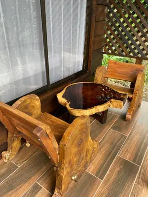 a bench and a table and a chair on a porch at La Fortuna Waterfall Bungalows in Fortuna