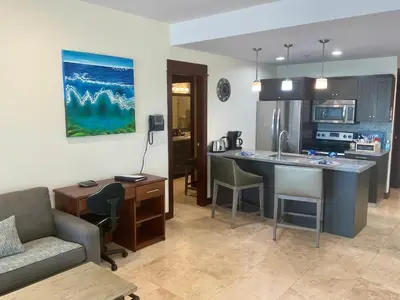 a kitchen and living room with a couch and a table at Jaco Oceanfront Condo #1119 in a Luxury Resort in Jacó