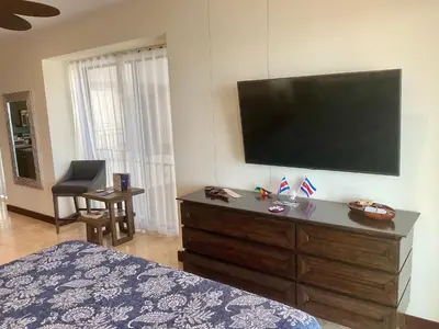 a bedroom with a large flat screen tv on the wall at Jaco Oceanfront Condo #1119 in a Luxury Resort in Jacó