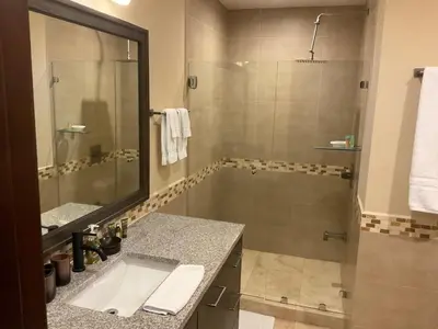 a bathroom with a shower and a sink and a tub at Jaco Oceanfront Condo #1119 in a Luxury Resort in Jacó