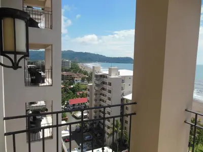 a view of the beach from the balcony of a building at Jaco Oceanfront Condo #1119 in a Luxury Resort in Jacó