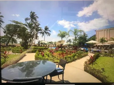 a patio with a table and chairs and a garden at Jaco Oceanfront Condo #1119 in a Luxury Resort in Jacó