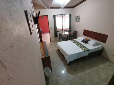 a bedroom with a bed and a table in it at HOTEL Cabinas JACOMAR in Jacó