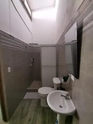 a bathroom with a sink and a toilet and a mirror at HOTEL Cabinas JACOMAR in Jacó