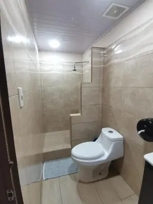 a bathroom with a toilet and a shower at HOTEL Cabinas JACOMAR in Jacó