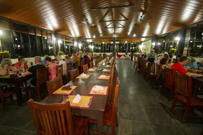 a group of people sitting at tables in a restaurant at Cañon de la Vieja Lodge in Liberia