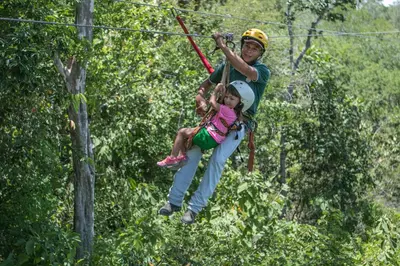 a man and a little girl on a zip line at Cañon de la Vieja Lodge in Liberia