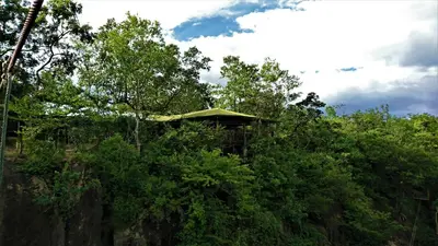 a building on top of a hill with trees at Cañon de la Vieja Lodge in Liberia