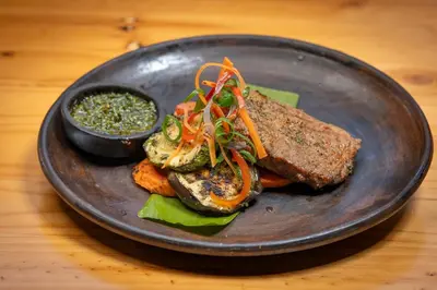 a plate of food with meat and vegetables on a table at Buena Vista del Rincón Eco Adventure Park Hotel & Spa in Liberia