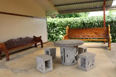 a table and stools in a patio with two benches at Cabinas Sueño Real in San Rafael